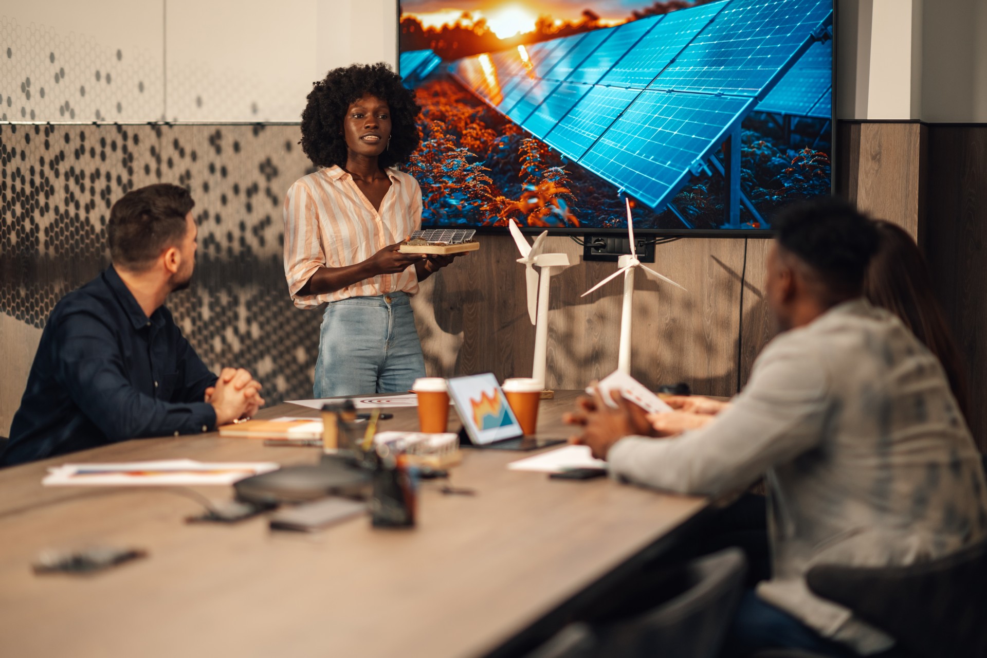 Ingénieur interracial avec des panneaux solaires ayant un séminaire avec des experts.